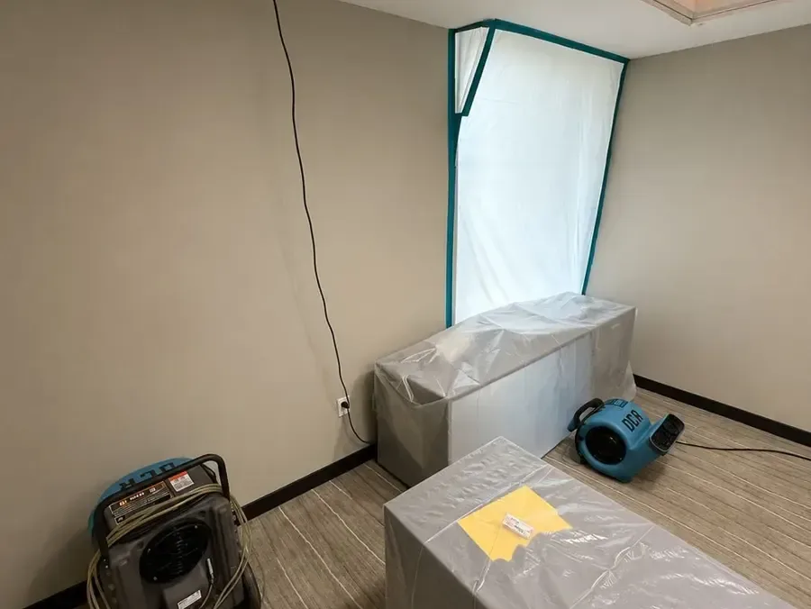 Plastic containment around furniture with an air mover in a room during drying