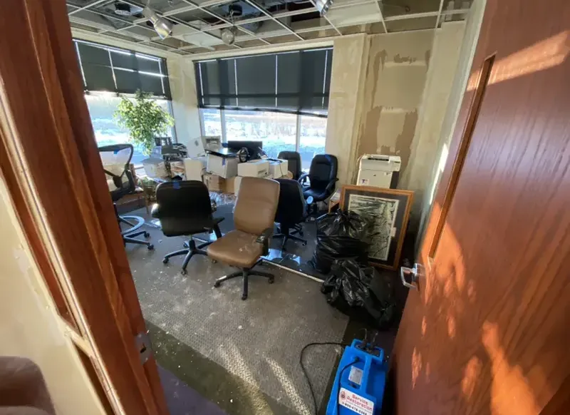 Blue drying equipment set among office desks and chairs after water damage