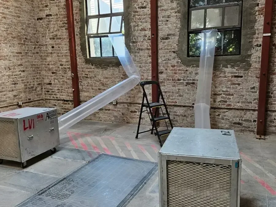 Ducted drying equipment arranged in a room with exposed brick walls